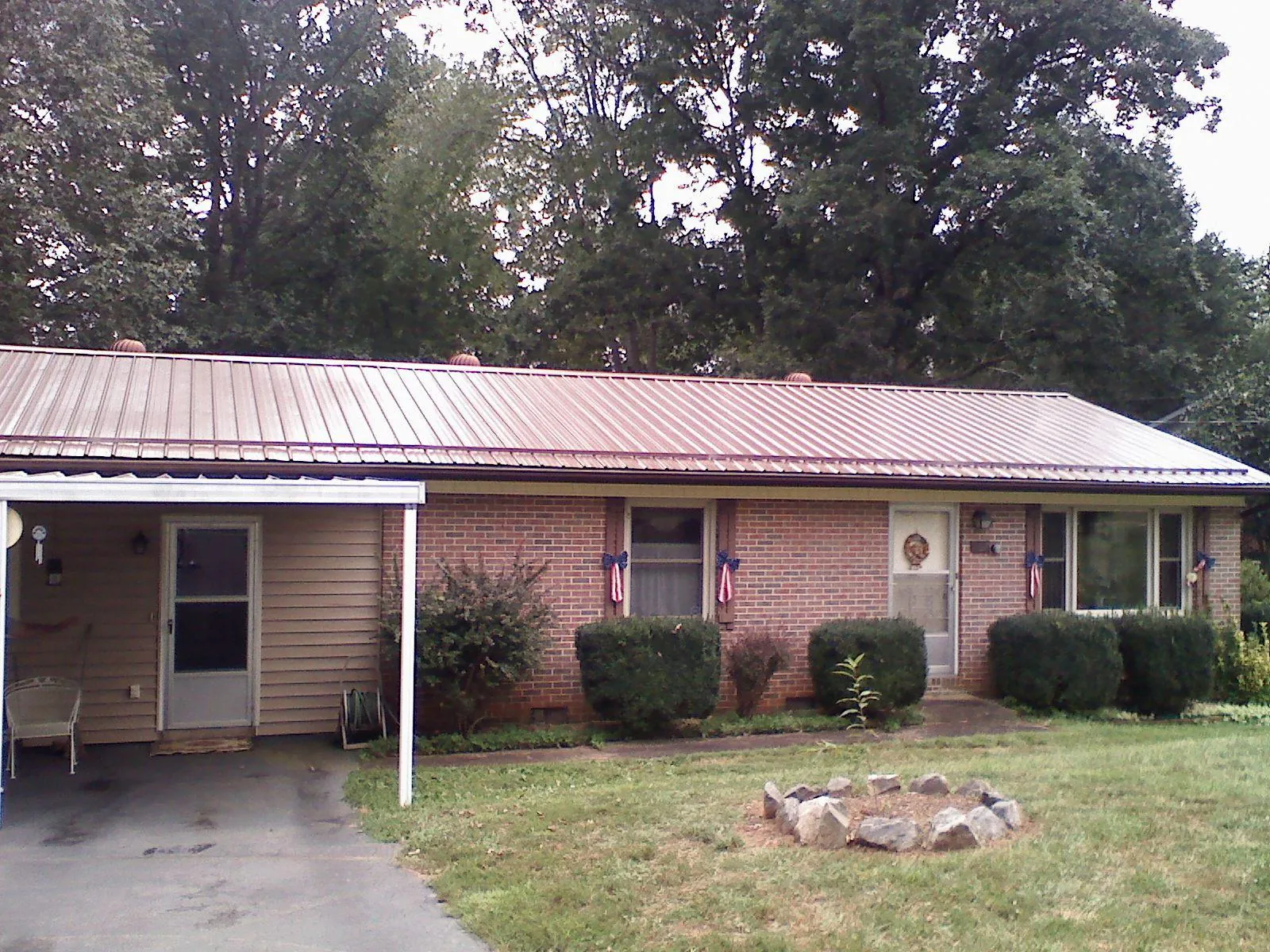 Bronze metal roof and carport on a brick ranch home — Roof Repair work by our crew in Ashland